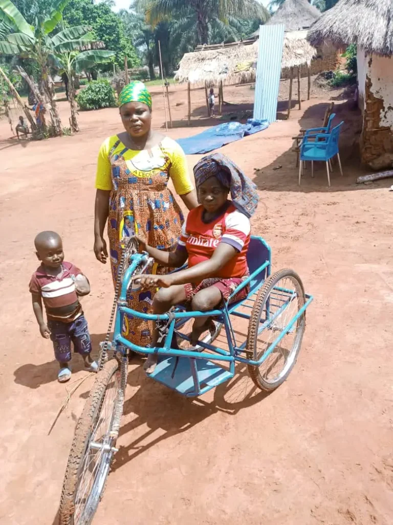 Photo de Nicole dans son vélo adapté pour une personne en situation de handicap, illustrant le projet Handicap soutenu par l'association SOLASO77 à Bongboka-Monéné en république démocratique du Congo RDC